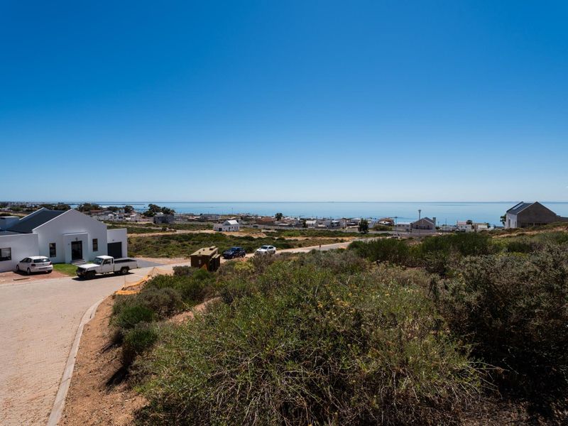 An elevated view of the residential vacant land overlooking the coastal town and ocean horizon.