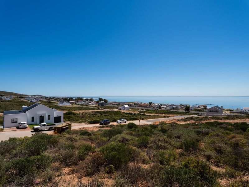 A wide-angle view of the coastal landscape and surrounding residential area, showcasing the property's elevated position and scenic outlook.