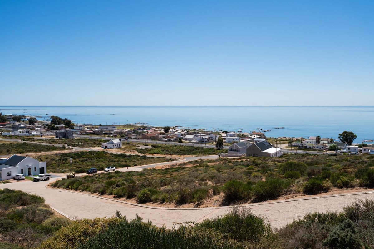 Elevated view overlooking the coastal residential area and the ocean, showcasing the surrounding landscape and local infrastructure.