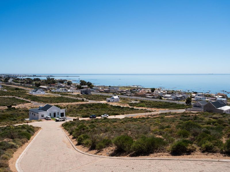 Elevated view overlooking the coastal landscape, surrounding residential properties, and the ocean horizon.