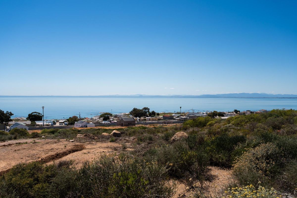 A scenic elevated view overlooking the coastal town and the ocean horizon from the vacant residential land.