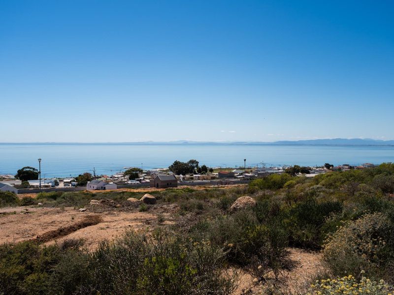 A scenic elevated view overlooking the coastal town and the ocean horizon from the vacant residential land.
