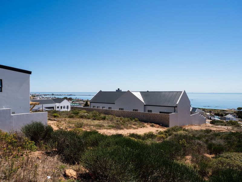 A scenic elevated view overlooking a coastal residential area with modern homes and a clear ocean horizon.