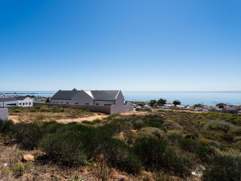 A scenic elevated view overlooking the coastal landscape and ocean, showcasing the surrounding residential area and natural terrain.