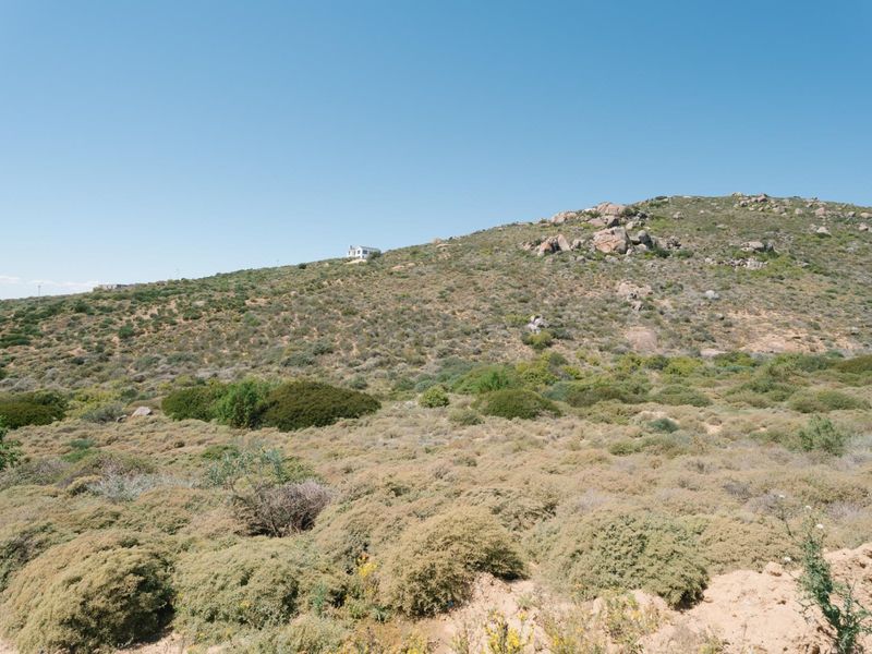 A wide-angle view of the vacant residential land, showcasing the natural topography, rocky outcrops, and native coastal vegetation characteristic of the area.