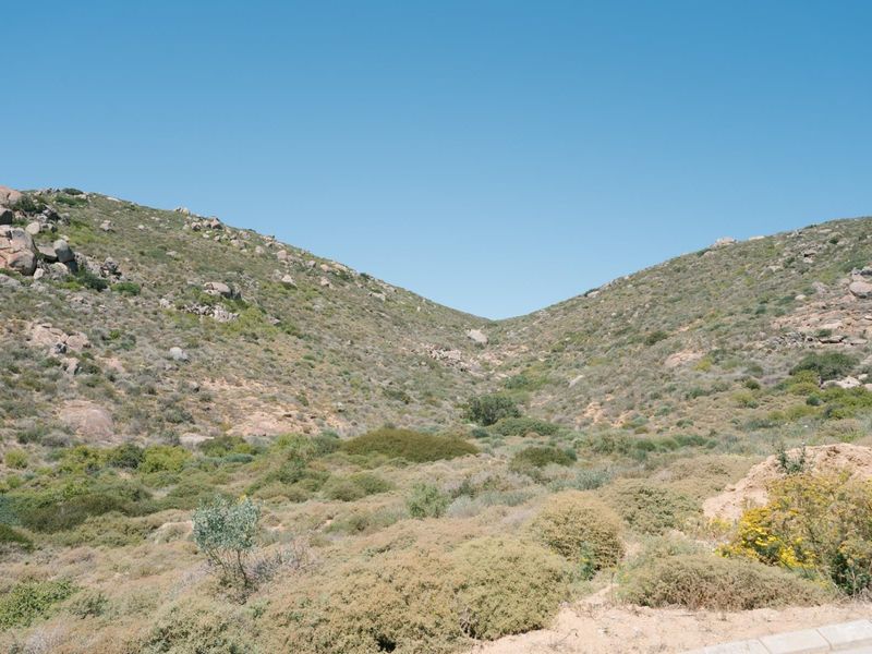 A scenic view of the natural, undeveloped landscape featuring rocky hills and native vegetation, characteristic of the vacant residential land.