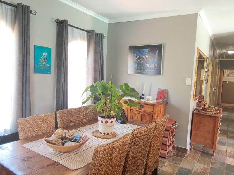 A dining area featuring slate tile flooring and classic cove cornicing, leading into a hallway with an arched transition.