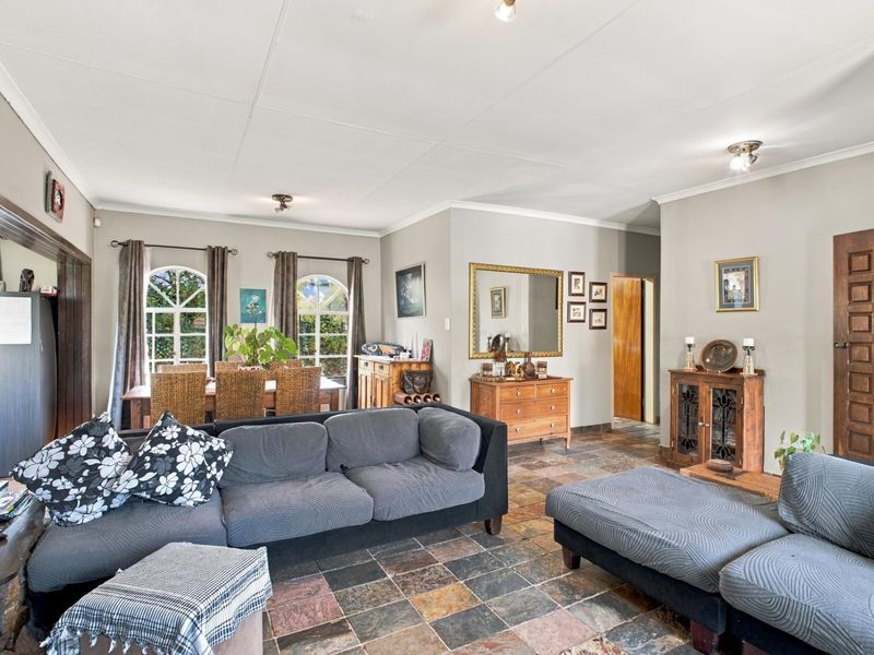 Spacious open-plan living and dining area featuring distinctive multi-colored tiled flooring, arched windows, and neutral wall finishes.