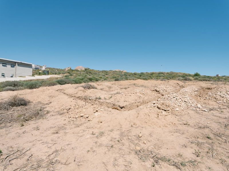 A vacant residential plot featuring excavated foundation trenches, ready for development in a quiet, natural landscape setting.