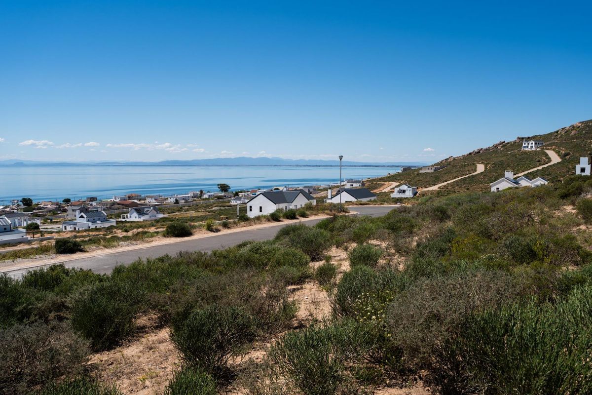 A scenic elevated view overlooking a coastal residential area with paved roads and distant ocean vistas.