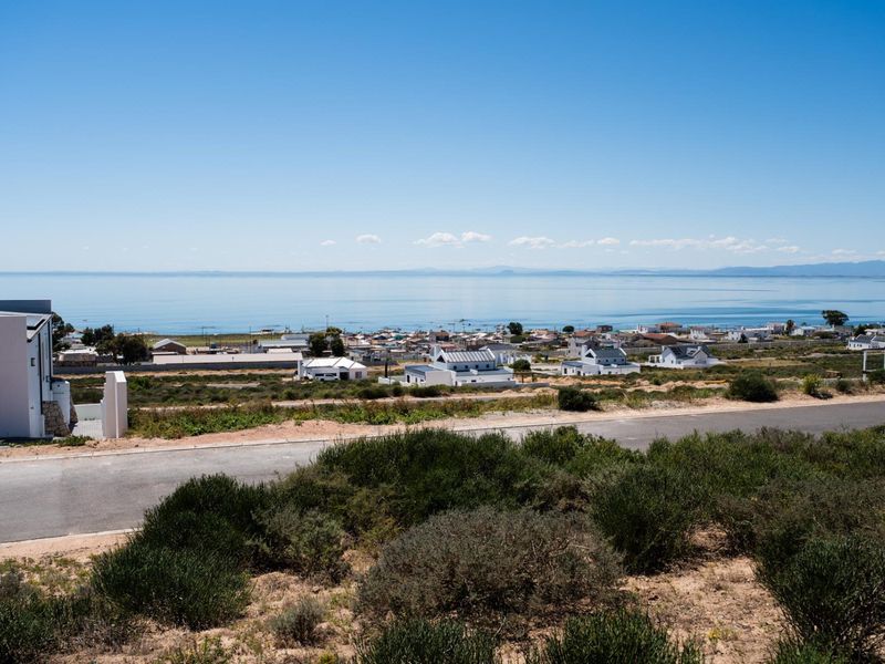 A scenic elevated view overlooking the coastal landscape, nearby residential properties, and the ocean horizon.