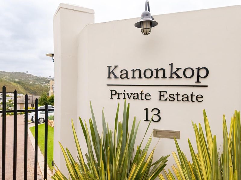Entrance view of Kanonkop Private Estate featuring a clean boundary wall, estate signage, and secure metal gate access.