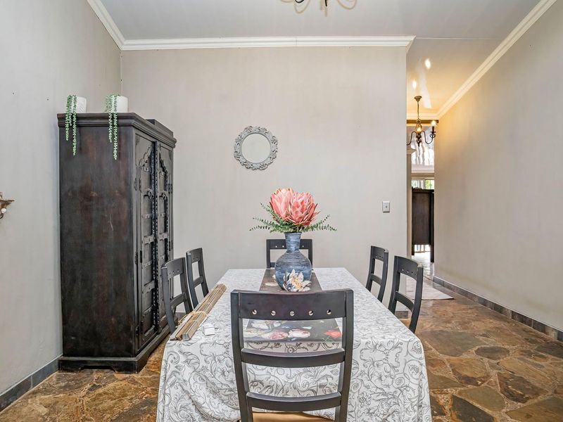 A dining room featuring natural stone flooring and neutral wall finishes, providing a rustic foundation for a formal dining area.