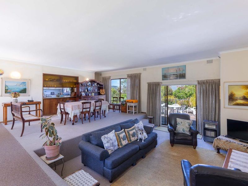 Spacious open-plan living and dining area featuring a sunken lounge, built-in cabinetry, and sliding glass doors leading to an outdoor patio.