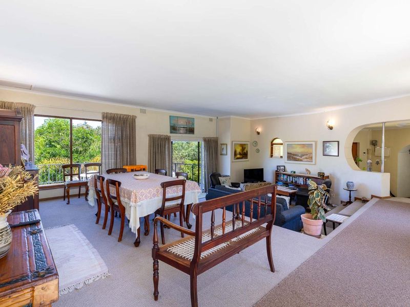 Spacious open-plan living and dining area featuring carpeted floors, an architectural archway, and large sliding glass doors providing access to the outdoor space.