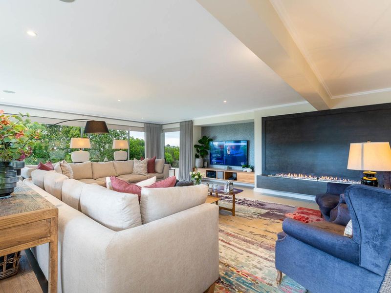 Spacious and modern living room featuring a sleek built-in fireplace, recessed lighting, and expansive sliding glass doors that provide ample natural light.