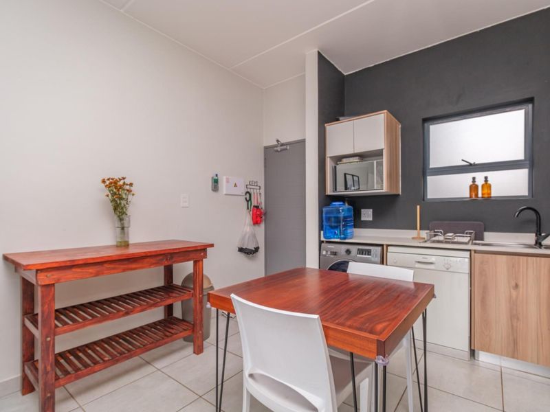 A functional kitchen area featuring built-in cabinetry, laminate countertops, a stainless steel sink, and tiled flooring, providing a practical space for daily use.