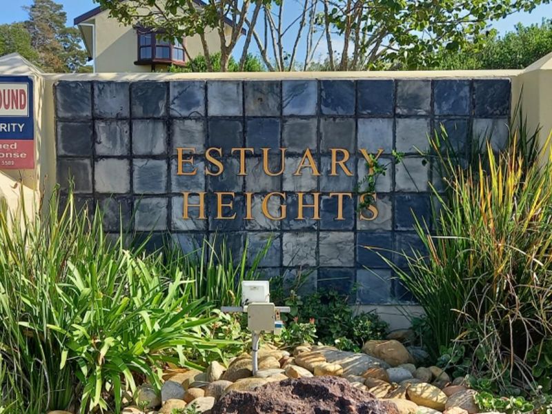 Entrance signage and boundary wall for Estuary Heights residential estate, featuring stone cladding and security gate access.