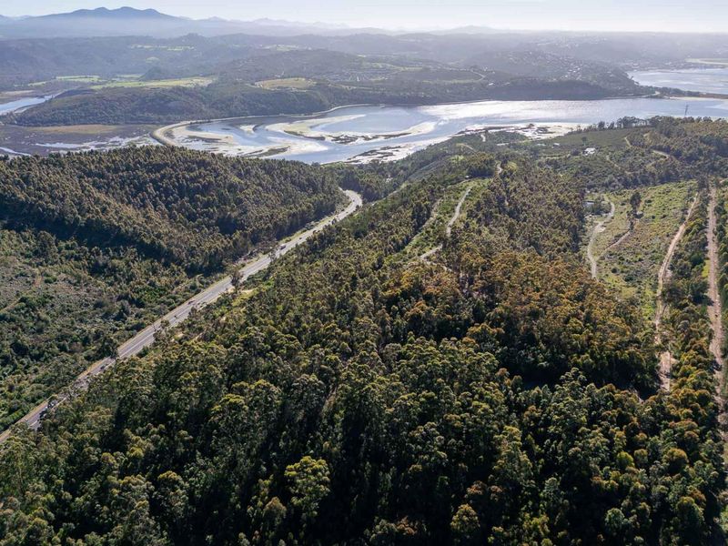 An expansive aerial view of the property landscape, featuring dense forest, natural terrain, and proximity to the river and surrounding valley.