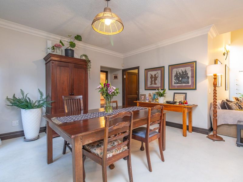 A well-lit dining room featuring crown molding, neutral wall finishes, and classic skirting boards, providing a comfortable space for family meals.