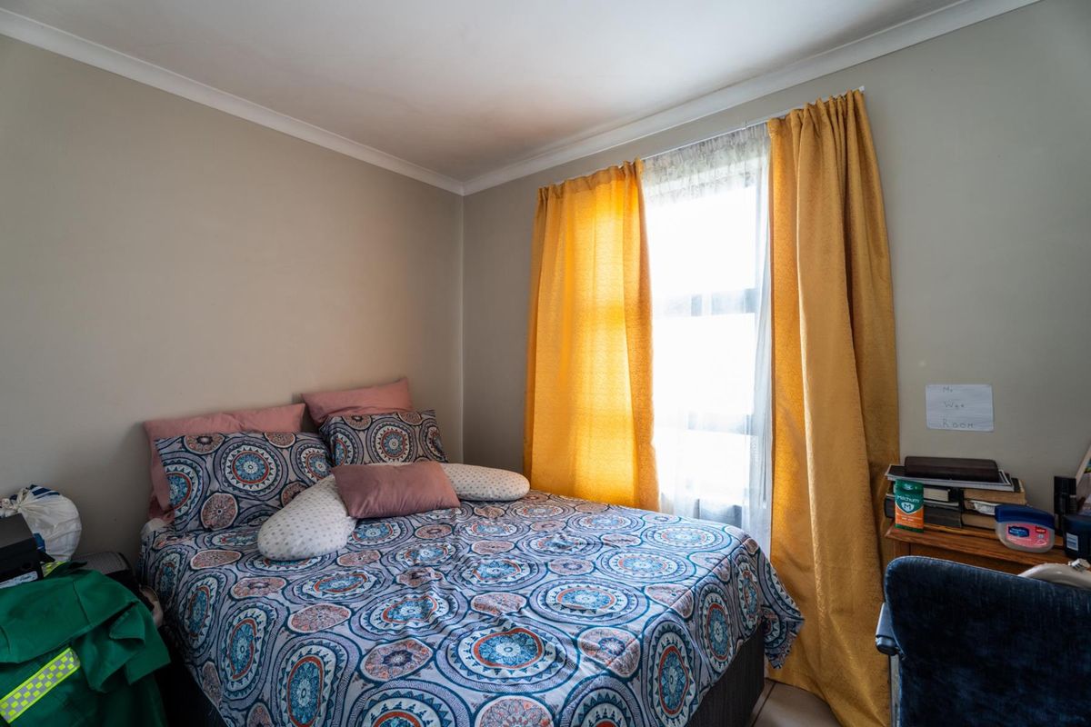 A standard bedroom featuring a window with curtains and coving detail, providing a functional space for rest.