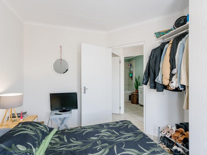 A bedroom featuring a built-in closet and direct access to an en-suite bathroom, finished with neutral walls and coving.
