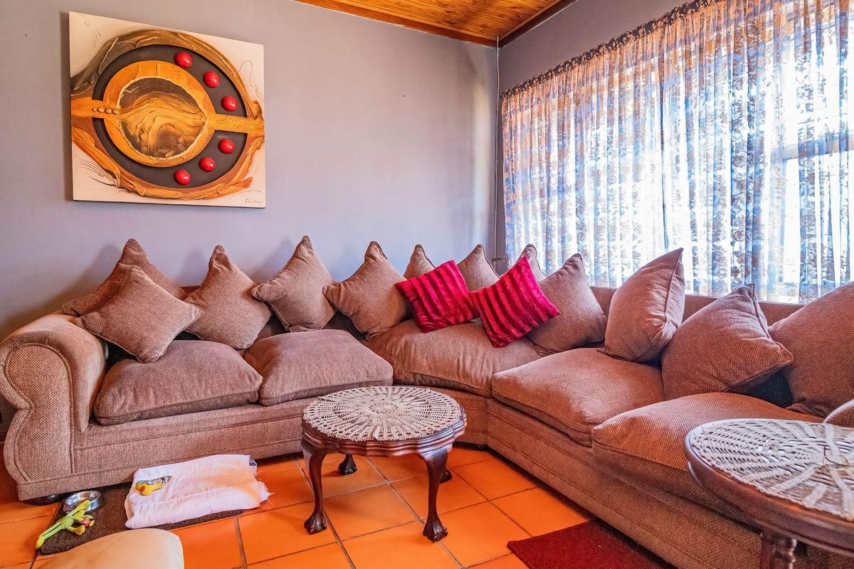 A cozy living room featuring warm terracotta floor tiles and a natural wood-paneled ceiling, creating a comfortable and inviting atmosphere.