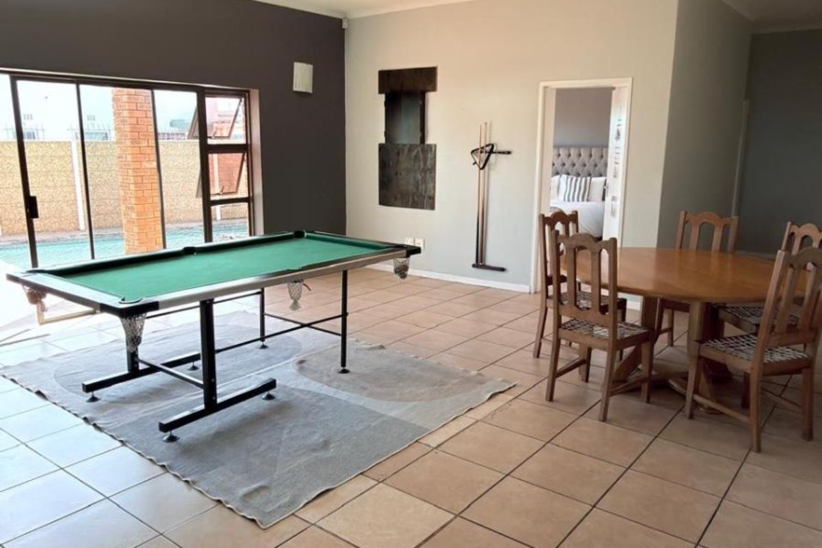 Spacious living area featuring tiled flooring and large sliding glass doors providing direct access to the outdoor pool area.