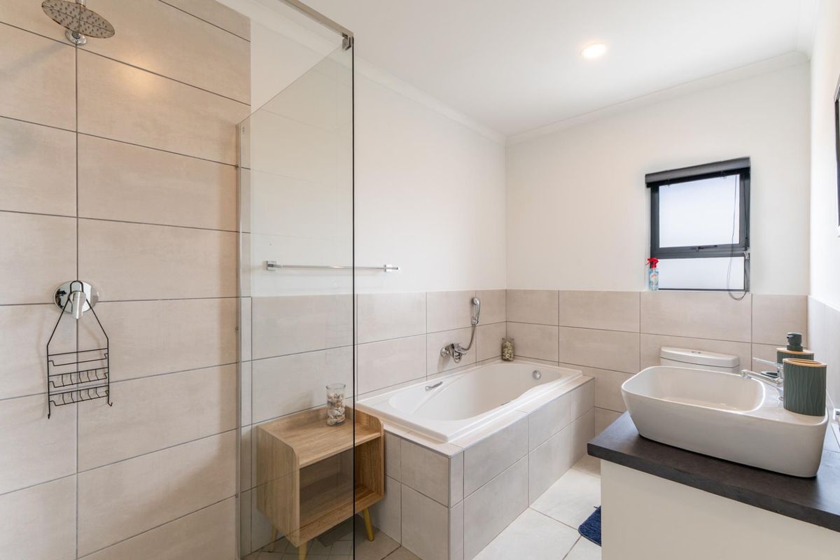 Modern bathroom featuring a walk-in shower with glass screen, built-in bathtub, and a contemporary vessel sink vanity.
