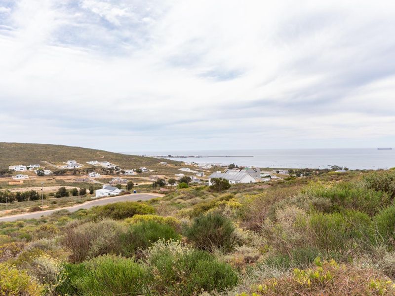A scenic elevated view overlooking the coastal landscape, surrounding residential properties, and the ocean horizon.