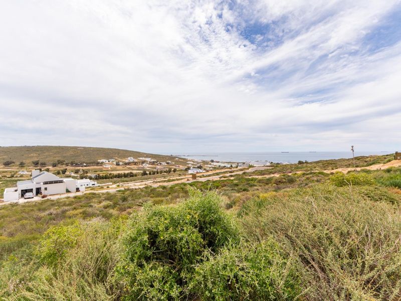 A scenic elevated view overlooking the coastal landscape and surrounding residential area, showcasing the natural terrain and proximity to the ocean.