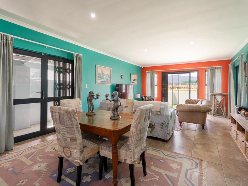 Spacious open-plan living and dining area featuring tiled floors, recessed lighting, and large sliding glass doors providing access to the outdoor space.