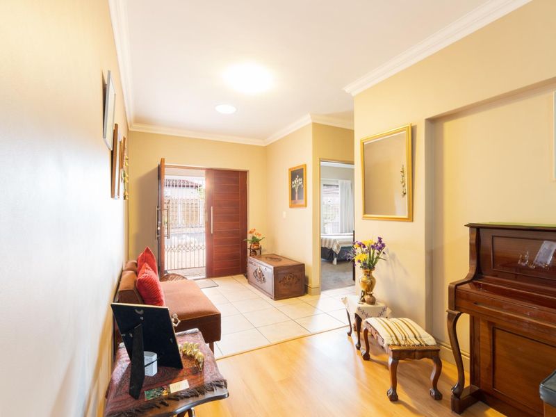 Welcoming entrance hall featuring a combination of tiled and laminate flooring, leading through to the main living areas of the home.