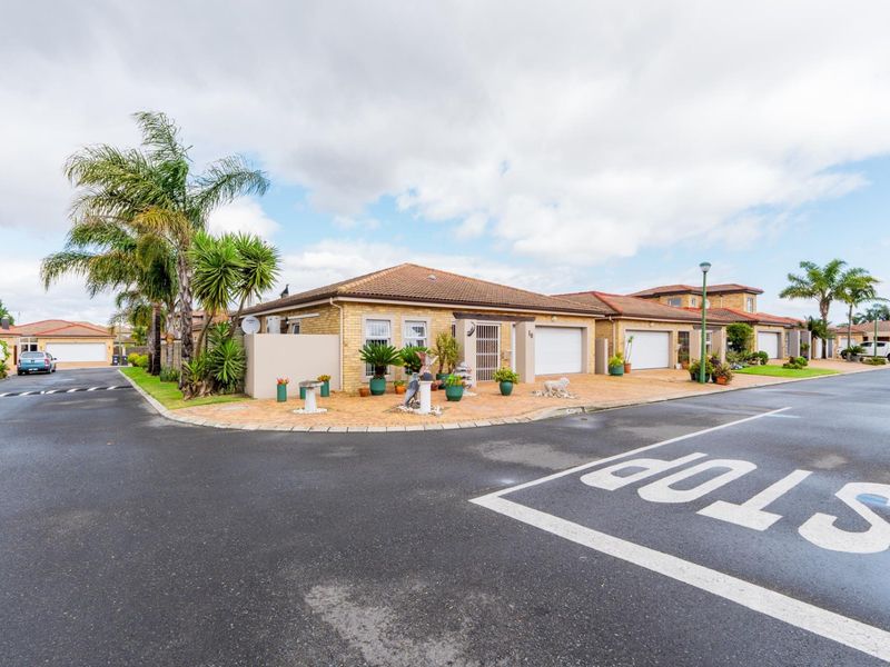 A well-maintained single-story brick house featuring a tiled roof, paved driveway, and secure garage access within a residential estate setting.