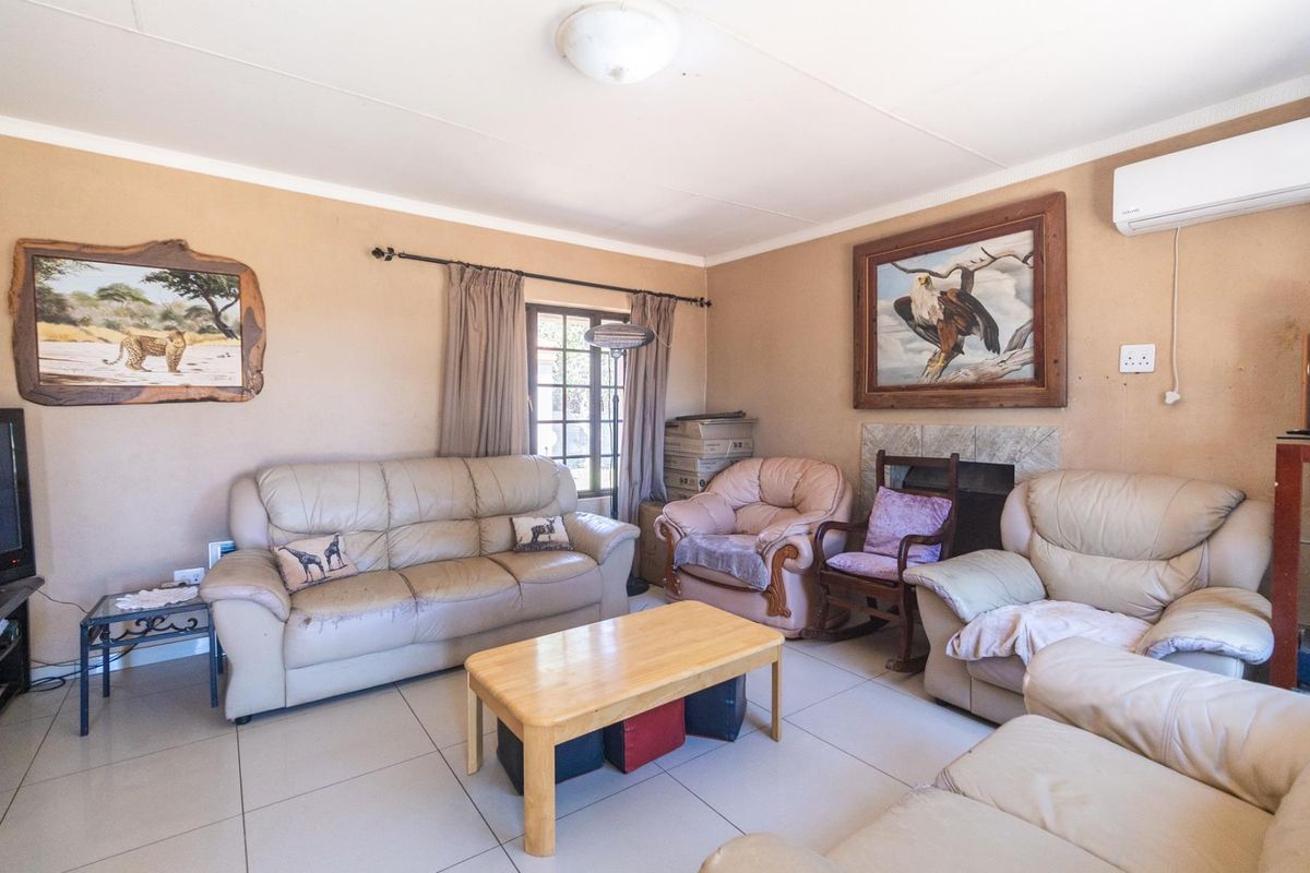 A comfortable living room featuring tiled flooring, a built-in fireplace, and a wall-mounted air conditioning unit.