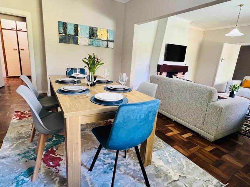 Open plan living and dining area featuring classic parquet flooring and a central fireplace, creating a warm and inviting atmosphere.