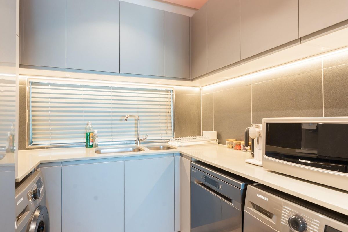 Modern, well-appointed kitchen featuring sleek cabinetry, integrated appliances, stone countertops, and under-cabinet LED lighting for a clean, functional workspace.