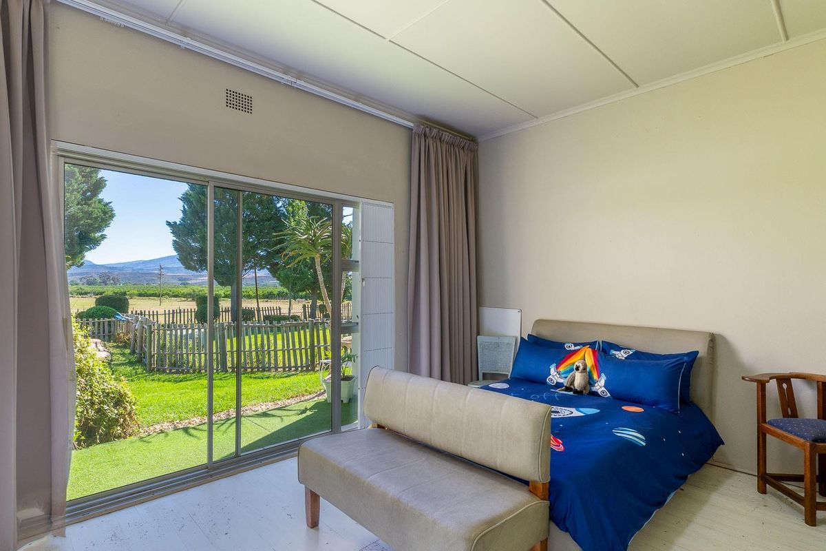 A bedroom featuring large sliding glass doors that provide direct access to the garden and scenic farm views.