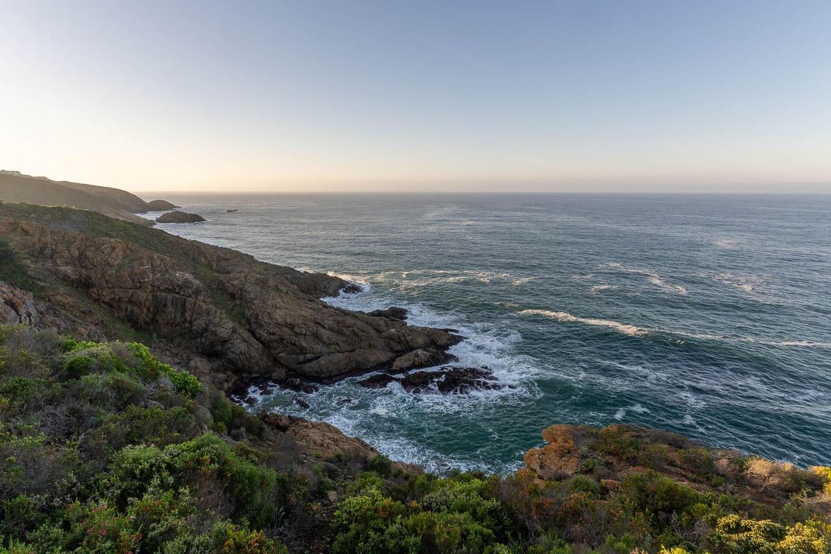 A scenic coastal view overlooking the ocean and rocky shoreline, highlighting the natural landscape and waterfront setting of the property.