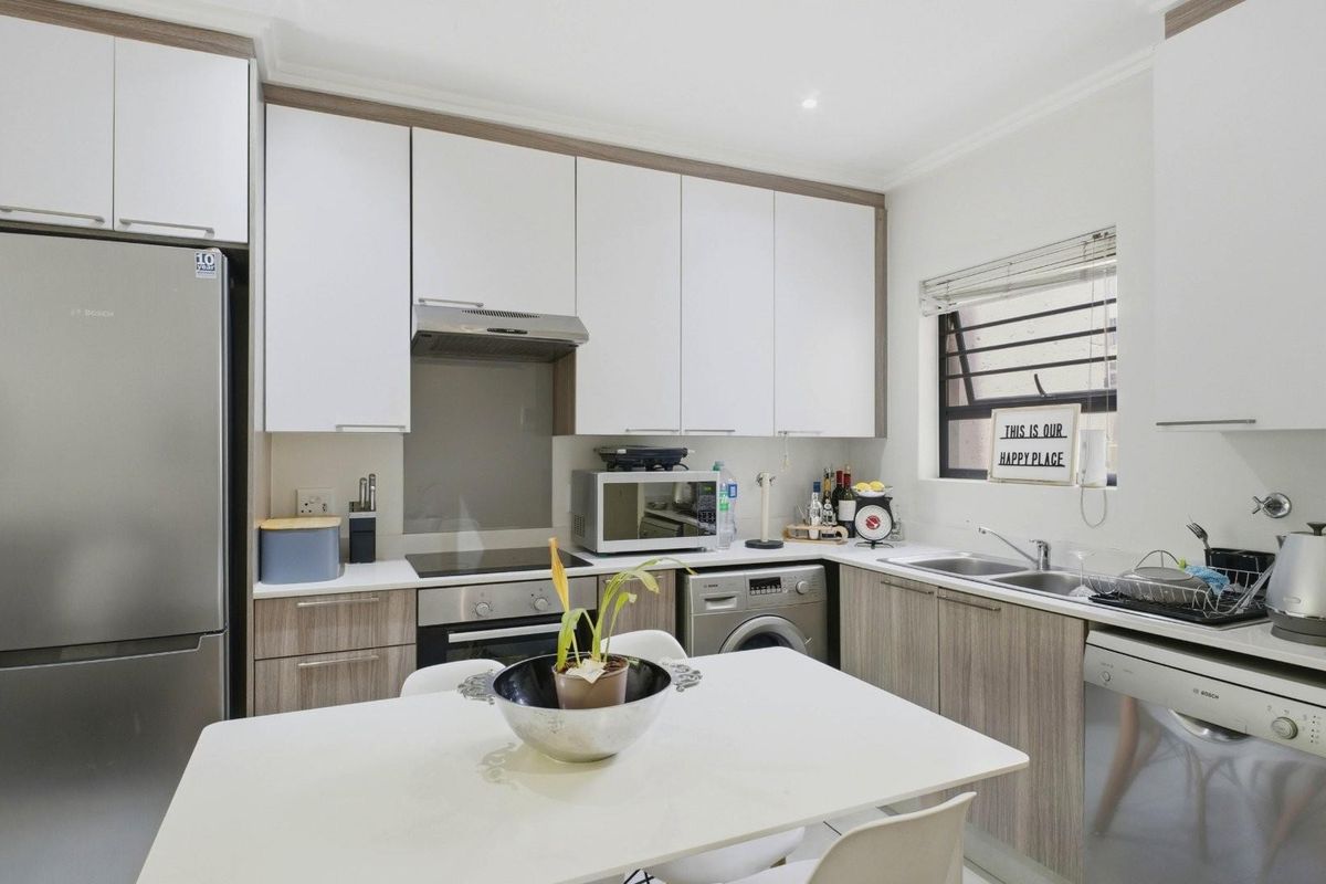 Modern kitchen featuring sleek cabinetry, integrated appliances, a built-in oven and hob, and a functional layout with ample storage space.