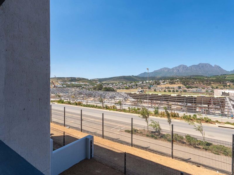 Elevated view overlooking a road, surrounding neighborhood, and distant mountain range.