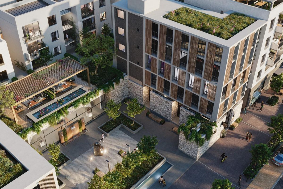 Aerial view of a modern apartment complex featuring landscaped courtyards, green roofs, and contemporary architectural design with stone and timber facade elements.