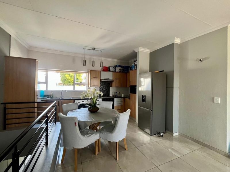 Open-plan kitchen and dining area featuring tiled flooring, modern cabinetry, and a functional layout with integrated kitchen fixtures.