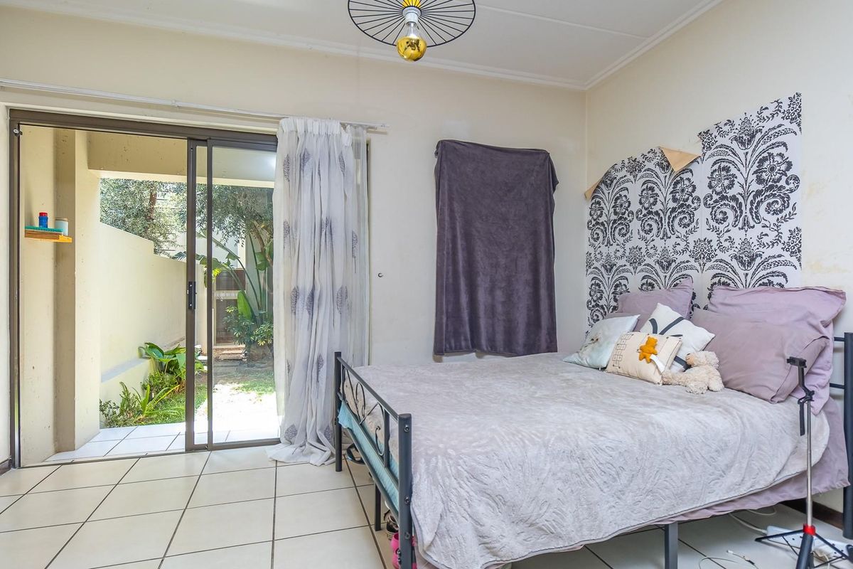 Bedroom featuring tiled flooring and sliding glass doors providing direct access to a private outdoor patio area.