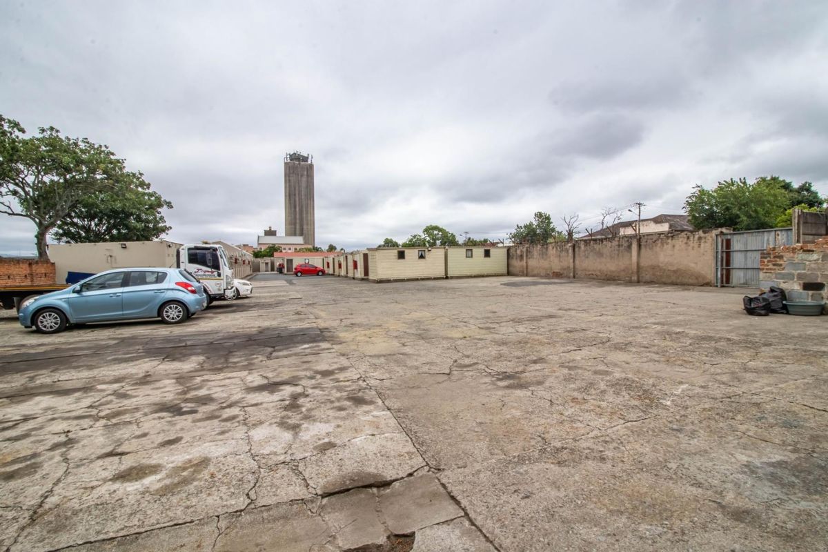 Expansive commercial yard area featuring a large concrete surface, perimeter boundary walls, and modular storage units.