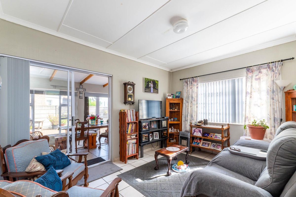 A living room featuring tiled flooring and sliding glass doors that provide access to an adjoining patio area.