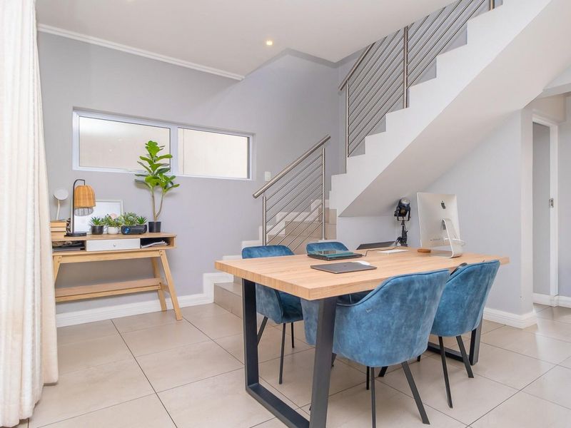 Open plan living area featuring modern tiled flooring, a contemporary staircase with stainless steel balustrades, and recessed lighting.