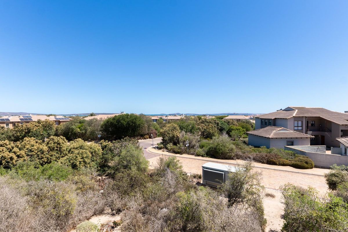 An elevated aerial view of the residential estate, showcasing the surrounding landscape, paved access roads, and neighboring property structures.