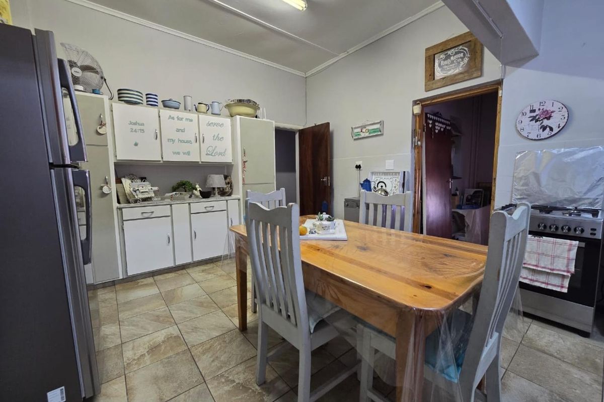 A functional kitchen and dining area featuring tiled flooring, built-in cabinetry, and a freestanding stove, offering a practical layout for daily living.