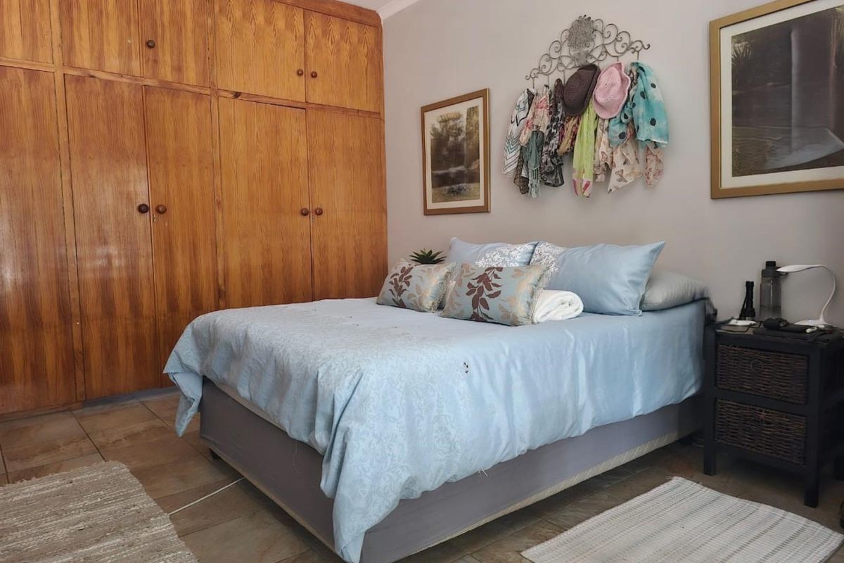 A bedroom featuring built-in wooden cabinetry and tiled flooring.